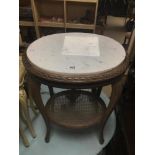 A FRENCH ORNATE OVAL SIDE TABLE WITH A WHITE MARBLE TOP AND A WICKER SHELF ON TURNED OUT LEGS