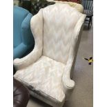 A VINTAGE WINGBACK ARMCHAIR WITH TURNED OUT ARM SUPPORTS