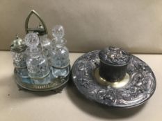 A SILVER PLATE AND GLASS FOUR PIECE CRUET SET, TOGETHER WITH AN ORNATE SILVER PLATE INKWELL STAND