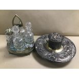 A SILVER PLATE AND GLASS FOUR PIECE CRUET SET, TOGETHER WITH AN ORNATE SILVER PLATE INKWELL STAND
