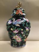 A CHINESE PORCELAIN LIDDED VASE, DECORATED WITH BIRDS AMONG-ST FLORAL SPRAYS, ON A BLACK GROUND, RED