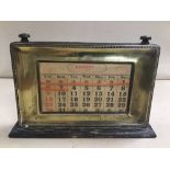 A VINTAGE BRASS AND WOOD DESK CALENDAR