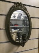 A BRASS WALL MIRROR WITH SINGLE ARM CANDLE WALL SCONCE, 35CM HIGH