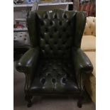 A VINTAGE GREEN LEATHER WINGCHAIR
