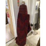 A LARGE ROLL OF DEEP RED AND BLACK MATERIAL