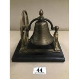 A BRASS ROCKING DESK BELL, MOUNTED ON WOODEN BASE