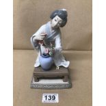 A LLADRO PORCELAIN FIGURE KNEELING JAPANESE WOMAN WITH VASE AND FLOWERS 20CMS