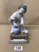 A LLADRO PORCELAIN FIGURE KNEELING JAPANESE WOMAN WITH VASE AND FLOWERS 20CMS