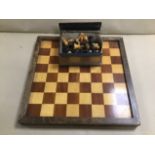 A CARVED WOODEN CHESS SET ON WOODEN BOARD