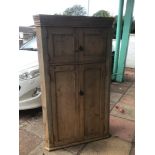 A VINTAGE PINE CORNER CUPBOARD WITH TWO COMPARTMENTS