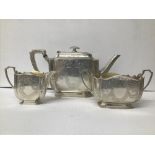 AN EDWARDIAN THREE PIECE SILVER TEA SET WITH ENGRAVED MOTIFS TO THE OUTER AND GILT INTERIOR,