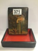 A RUSSIAN LAQUERED BOX OF RECTANGULAR FORM, THE LID WITH DECORATION DEPICTING A GIRL HOLDING A
