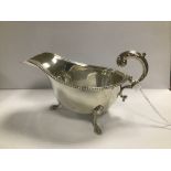 AN EARLY 20TH CENTURY SILVER SAUCEBOAT WITH BEADED BORDER AND SCROLL HANDLE, HALLMARKED BIRMINGHAM