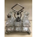 AN EARLY 20TH CENTURY SIX PIECE CUT GLASS CONDIMENT SET, MOUNTED UPON SILVER PLATE STAND BY DANIEL &