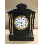 A LATE 19TH CENTURY SLATE MANTLE CLOCK, THE ENAMEL DIAL WITH ROMAN NUMERALS DENOTING HOURS, IN