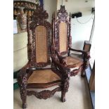 A PAIR OF REPRODUCTION KING THRONE CHAIRS WITH CLEAN WICKER SEATS AND BACKS WITH CARVED LIONS TO THE