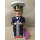 A STAFFORDSHIRE POTTERY CHARACTER JUG OF A NAVAL OFFICER HOLDING A TORPEDO, TITLED "DREAD NOUGHT"