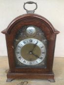 AN ELLIOT OF LONDON OAK CASED MANTLE CLOCK, THE SILVERED DIAL WITH ROMAN NUMERALS DENOTING HOURS,