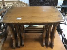 AN ERCOL NEST OF THREE TABLES WITH ORIGINAL LABELS TO UNDERSIDE, LARGEST 57CM WIDE