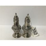 A PAIR OF LATE VICTORIAN SILVER EMBOSSED PEPPER POTS OF BALUSTER FORM, HALLMARKED CHESTER 1900 BY