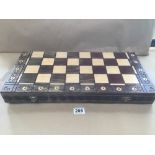 A CARVED WOODEN CHESS SET AND BOARD