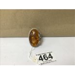 A LARGE UNMARKED SILVER AND AMBER RING, 15G