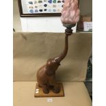 A WOODEN ELEPHANT FORMED AS A LIGHT WITH A PINK FROSTED SHADE 82CM A/F