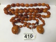 A LARGE AMBER NECKLACE OF GRADUATING FORM, 97G, TOGETHER WITH A SMALL NECKLACE AND A PAIR OF