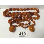 A LARGE AMBER NECKLACE OF GRADUATING FORM, 97G, TOGETHER WITH A SMALL NECKLACE AND A PAIR OF