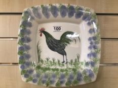 A MODERN CERAMIC WALL PLATE OF SQUARE FORM WITH HAND PAINTED COCKERAL TO FRONT, SIGNED TO REVERSE