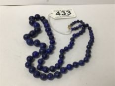 A LAPIS LAZULI NECKLACE OF GRADUATED FORM WITH 9CT GOLD CLASP