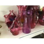 A LARGE COLLECTION OF CRANBERRY GLASS, INCLUDING VASES, POURING JUGS AND MORE