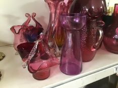 A LARGE COLLECTION OF CRANBERRY GLASS, INCLUDING VASES, POURING JUGS AND MORE