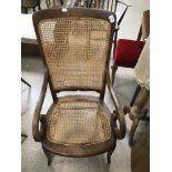 A CIRCA 19TH CENTURY MAHOGANY CANE WORKED ARM CHAIR