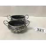 A PAIR OF LATE VICTORIAN SILVER EMBOSSED SALTS OF OVAL FORM WITH TWIN HANDLES, HALLMARKED