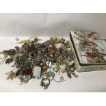 A TIN OF MIXED COSTUME JEWELLERY