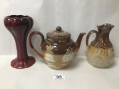 A DOULTON LAMBETH HARVEST WARE TEAPOT WITH A SIMILAR JUG AND A DOULTON FLAMBE VASE A/F