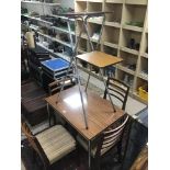 A 1960s FORMICA BROWN TABLE AND FOUR CHAIRS WITH A TWO TIER FOLDING SHELF UNIT.