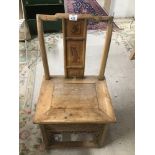 A SMALL JAPANESE CHAIR WITH CARVING TO THE BACK AND AROUND THE BASE