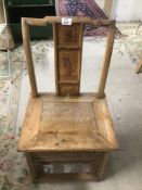 A SMALL JAPANESE CHAIR WITH CARVING TO THE BACK AND AROUND THE BASE