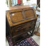 AN OAK BUREAU ON BARLEY TWIST LEGS.