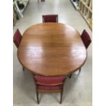 A 1970s MID-CENTURY TEAK EXTENDING DINING TABLE WITHN FOUR CHAIRS.
