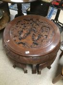 AN EASTERN CARVED ROUND TABLE WITH FOUR UNDER TABLES