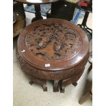 AN EASTERN CARVED ROUND TABLE WITH FOUR UNDER TABLES