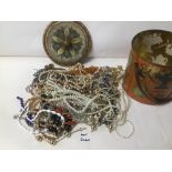 A TIN OF MIXED COSTUME JEWELLERY