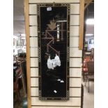 A JAPANESE BLACK LACQUERED WOODEN WALL PLAQUE DECORATED WITH MOTHER IN PEARL