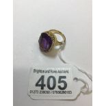 A LARGE SOLITAIRE OCTAGON-CUT AMETHYST STONE CLAW SET IN A YELLOW METAL MOUNT RING NO HALLMARK BUT