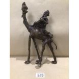 A BRONZE MIDDLE EASTERN FIGURE RIDING A CAMEL 33CM HIGH