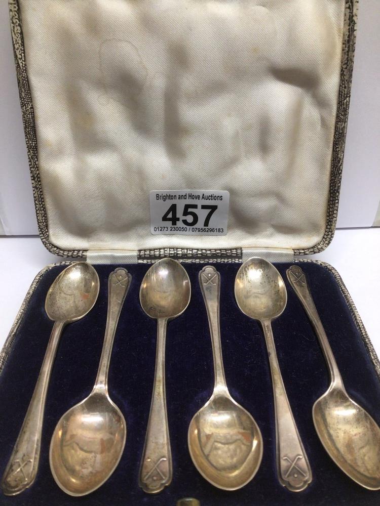 A CASED SET OF HALLMARKED SILVER TEASPOONS BY WALKER AND HALL WITH GOLF CLUBS EMBOSSED ON THEM