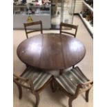 A MAHOGANY EXTENDING DINING TABLE WITH FOUR CHAIRS